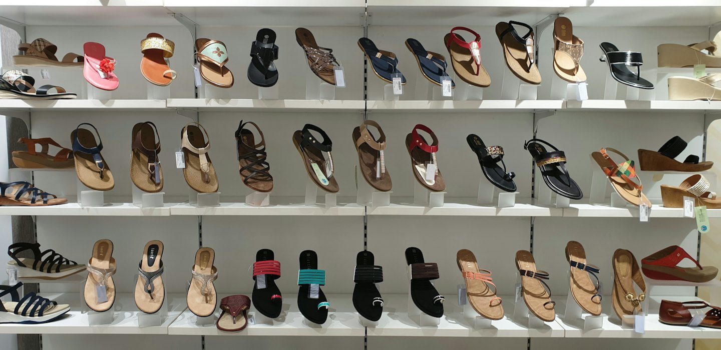Women's sandals displayed on white retail shelves.
