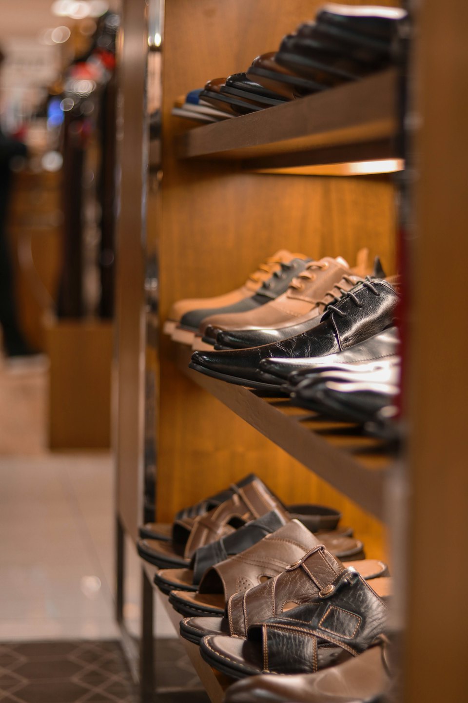 Men's leather shoes and sandals displayed on store shelves.